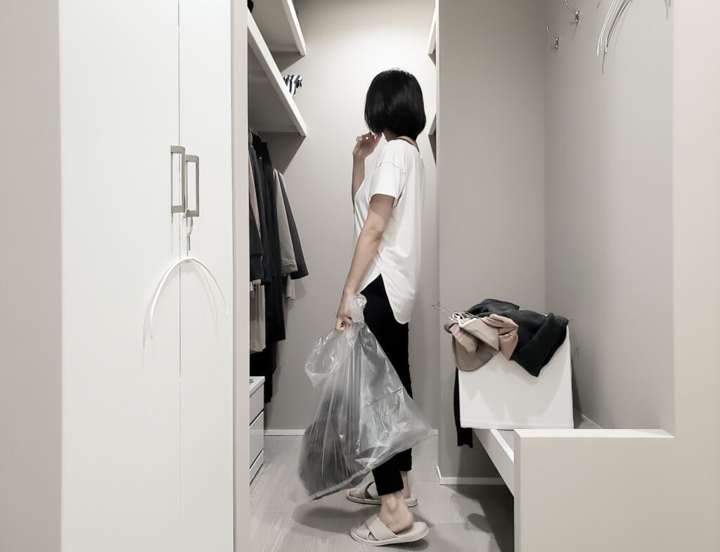 クローゼットで不要なものを仕分けしている女性