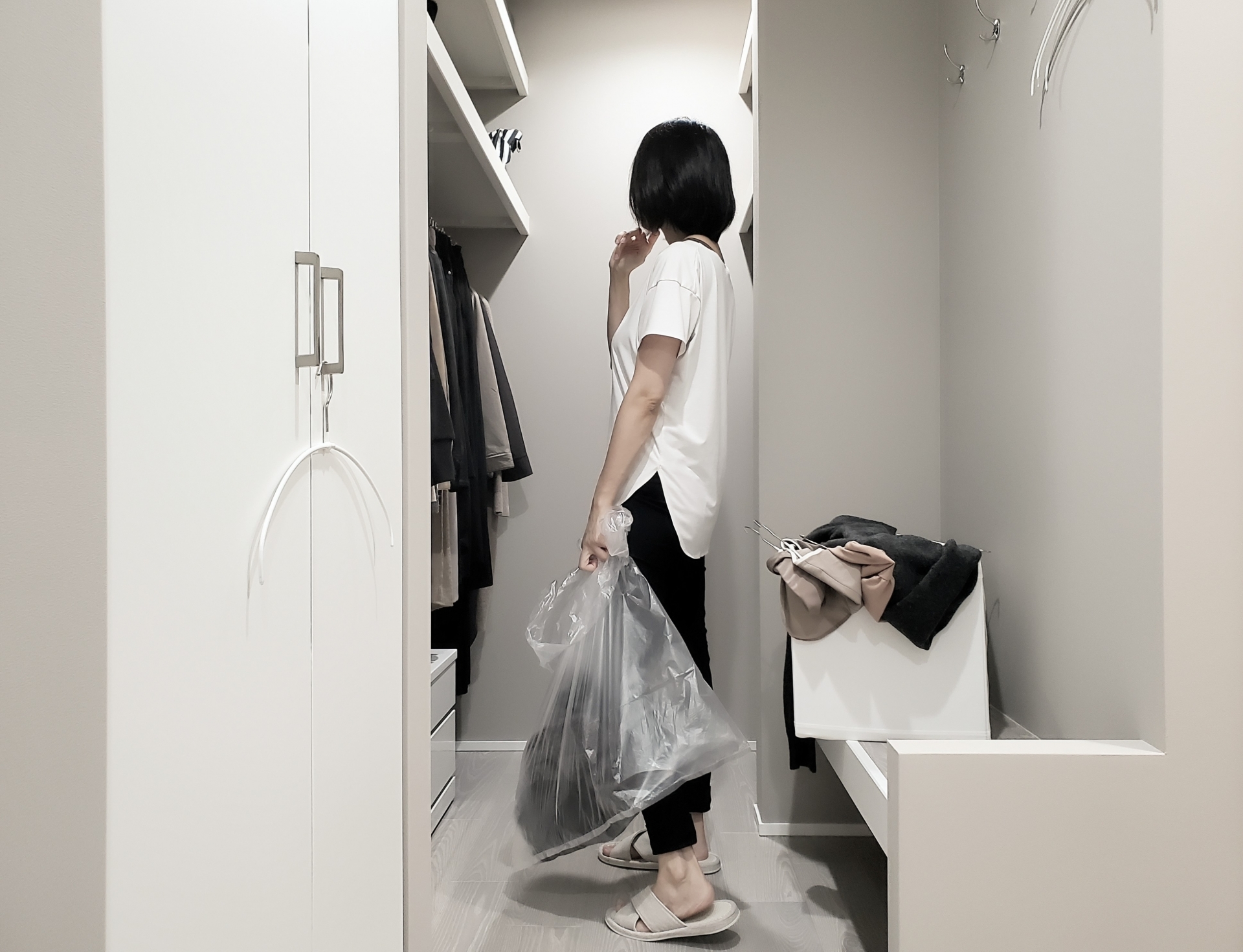 クローゼットで不要なものを仕分けしている女性