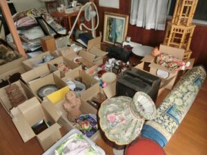 食器や置物などの家財を段ボールに仕分けしている室内