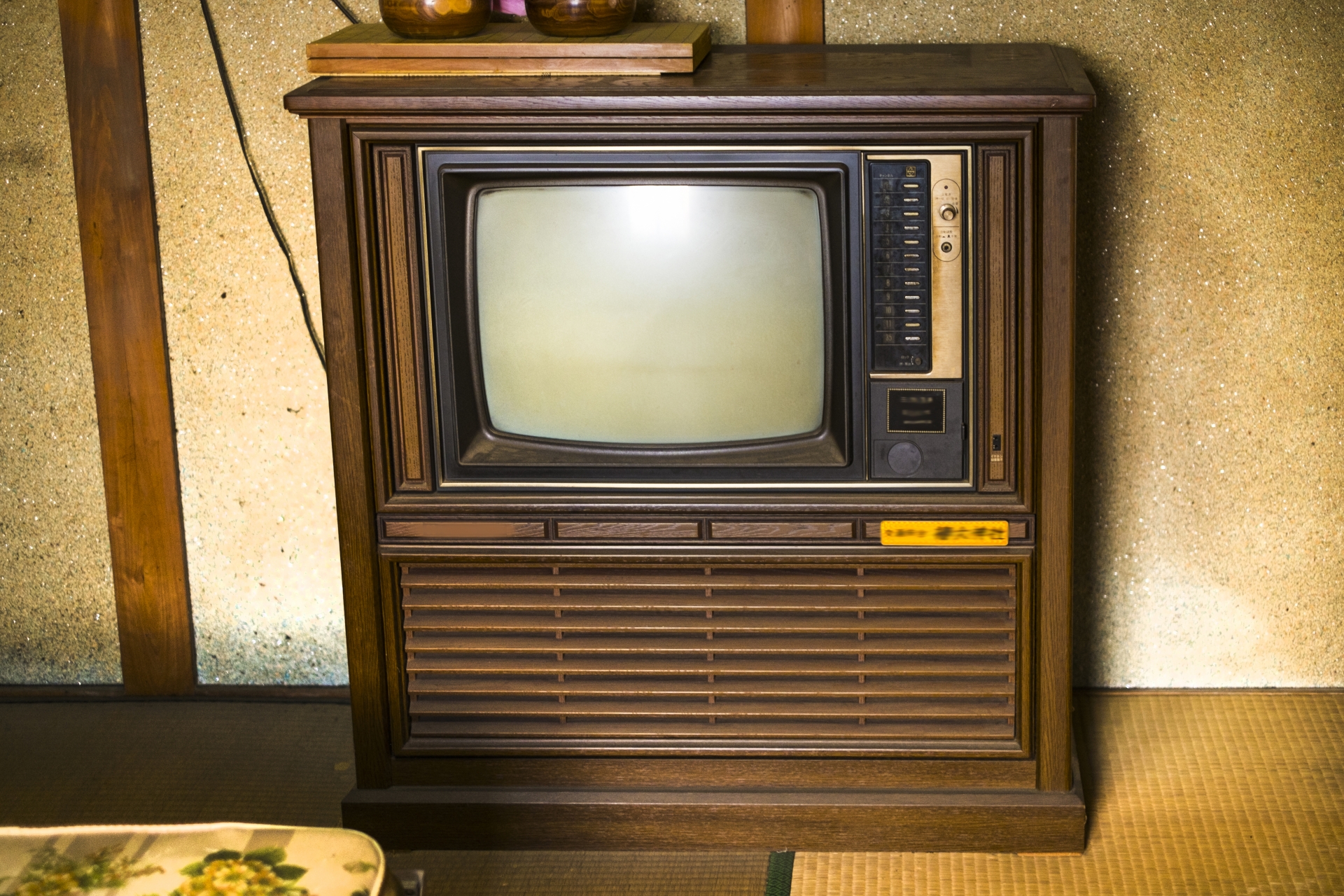和室に置かれた木目調の古いブラウン管テレビ